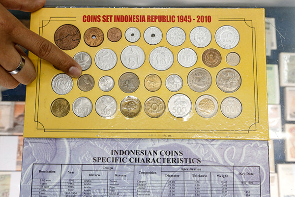 Seorang penjual uang kuno, David menunjukkan uang kuno koin Rp2 perak tahun 1945 di tokonya di kawasan pertokoan Pasar Baru, Jakarta Pusat, Sabtu (11/9/2021).