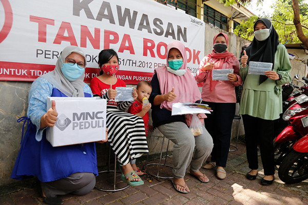 Relawan saat membagikan masker dan sosialiasasi pentingnya protokol kesehatan di Pela Mampang, Jakarta Selatan, Senin (13/9/2021).