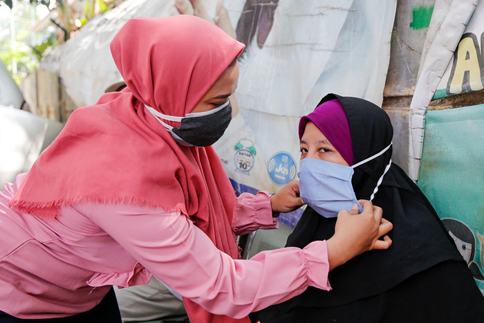 Relawan saat membagikan masker dan sosialiasasi pentingnya protokol kesehatan di Pela Mampang, Jakarta Selatan, Senin (13/9/2021).