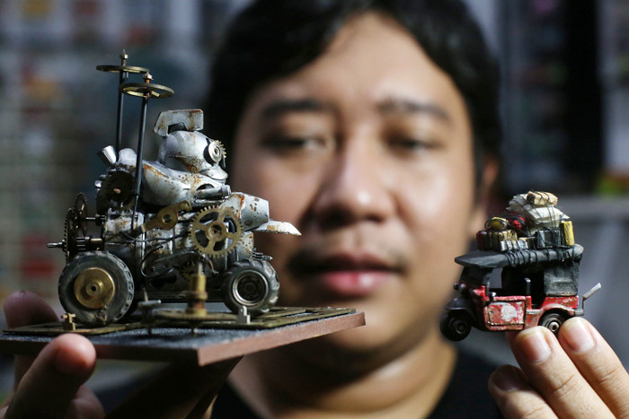 Perajin miniatur mobil, Adi Pradana Angga Nandyta, menyelesaikan pesanan miniatur mobil atau diecast di rumahnya di Surabaya, Jawa Timur, Senin (13/9/2021).