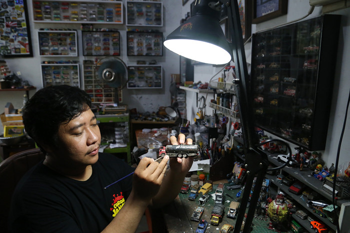 Perajin miniatur mobil, Adi Pradana Angga Nandyta, menyelesaikan pesanan miniatur mobil atau diecast di rumahnya di Surabaya, Jawa Timur, Senin (13/9/2021).