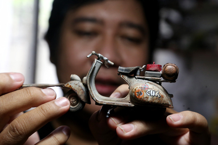 Perajin miniatur mobil, Adi Pradana Angga Nandyta, menyelesaikan pesanan miniatur mobil atau diecast di rumahnya di Surabaya, Jawa Timur, Senin (13/9/2021).