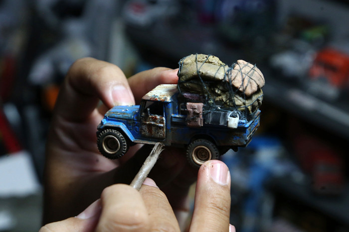 Perajin miniatur mobil, Adi Pradana Angga Nandyta, menyelesaikan pesanan miniatur mobil atau diecast di rumahnya di Surabaya, Jawa Timur, Senin (13/9/2021).