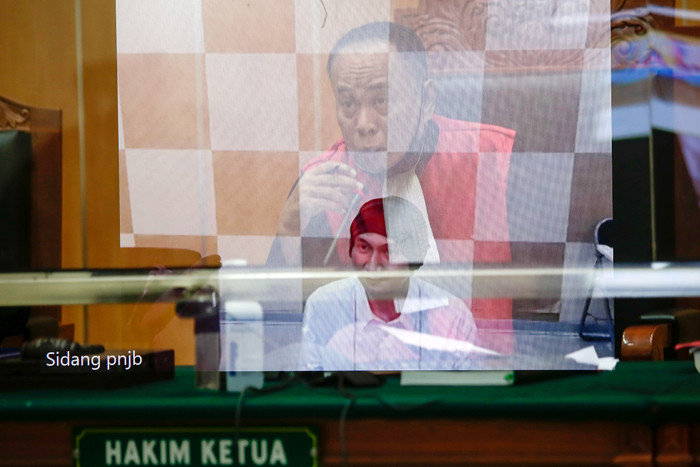Foto double exposure musisi Erdian Aji Prihartanto alias Anji saat menjalani sidang perdana yang digelar secara virtual di PN Jakarta Barat, Rabu (15/9/2021).