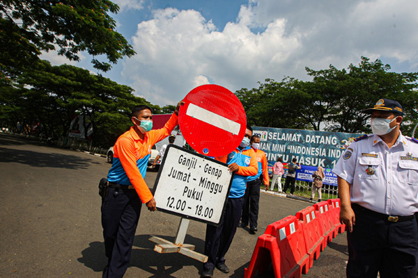 Petugas polisi dan dishub berjaga di depan Pintu 1 TMII, Jakarta Timur, Jumat (17/9/2021).