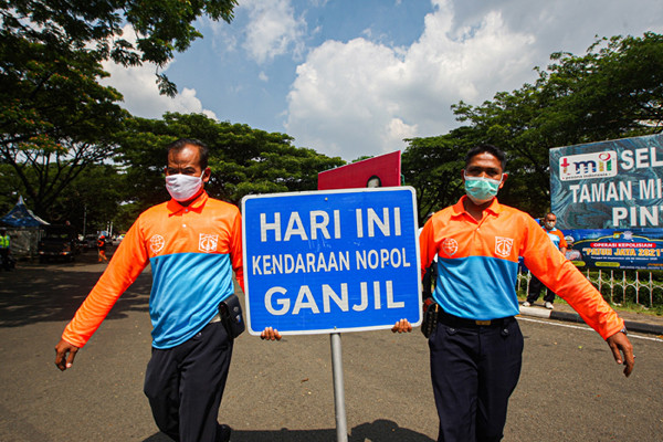 Petugas polisi dan dishub berjaga di depan Pintu 1 TMII, Jakarta Timur, Jumat (17/9/2021).