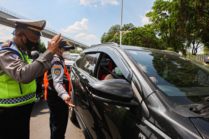 Petugas polisi dan dishub berjaga di depan Pintu 1 TMII, Jakarta Timur, Jumat (17/9/2021).