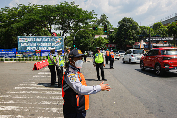 Petugas polisi dan dishub berjaga di depan Pintu 1 TMII, Jakarta Timur, Jumat (17/9/2021).