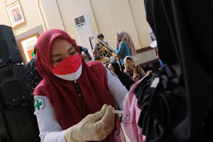 Suasana antusiasme warga mengantri untuk melakukan vaksin di Gedung Manunggal, Kota Makassar, Minggu (19/9/2021).