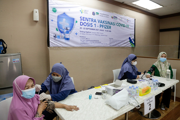 Vaksinator menyuntikkan vaksin Covid-19 jenis Pfizer kepada warga di Sentra Vaksinasi MNC Peduli di Gedung HighEnd, MNC Center, Kebon Sirih, Selasa (21/9/2021).