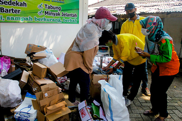 Warga mengumpulkan sampah yang akan dikonversi ke dalam buku tabungan di kawasan Jakarta Selatan, Selasa (21/9/2021).
