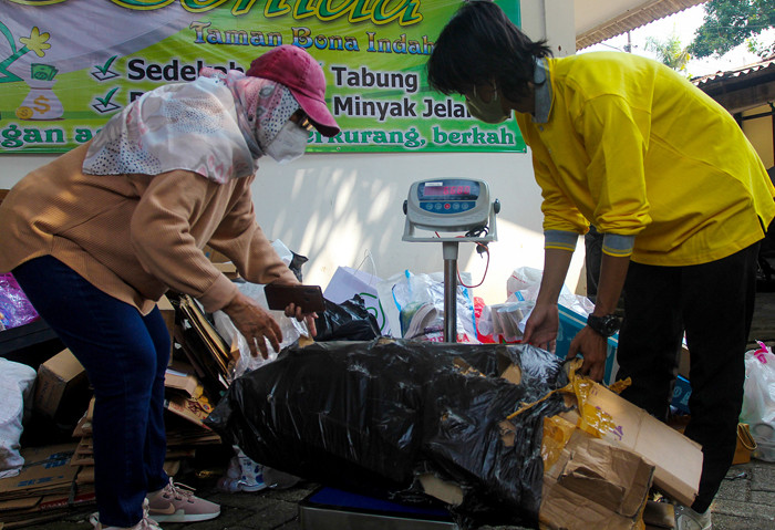Warga mengumpulkan sampah yang akan dikonversi ke dalam buku tabungan di kawasan Jakarta Selatan, Selasa (21/9/2021).