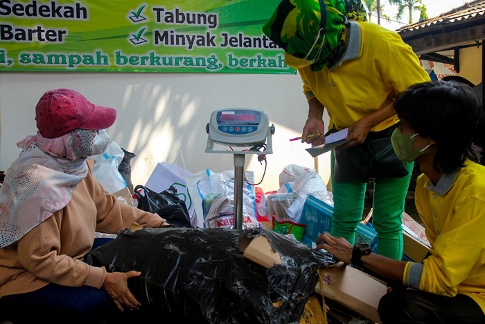 Warga mengumpulkan sampah yang akan dikonversi ke dalam buku tabungan di kawasan Jakarta Selatan, Selasa (21/9/2021).