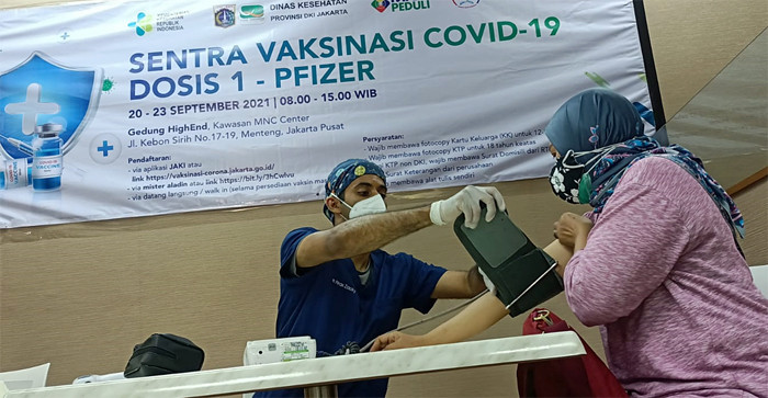 Vaksinator menyuntikkan vaksin Covid-19 kepada warga di Sentra Vaksinasi MNC Peduli di Jakarta, Kamis (23/9/2021).