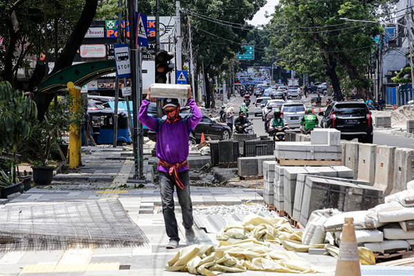 Pekerja menyelesaikan proyek revitalisasi trotoar di Jalan Senopati, Jakarta Selatan, Jumat (24/9/2021).