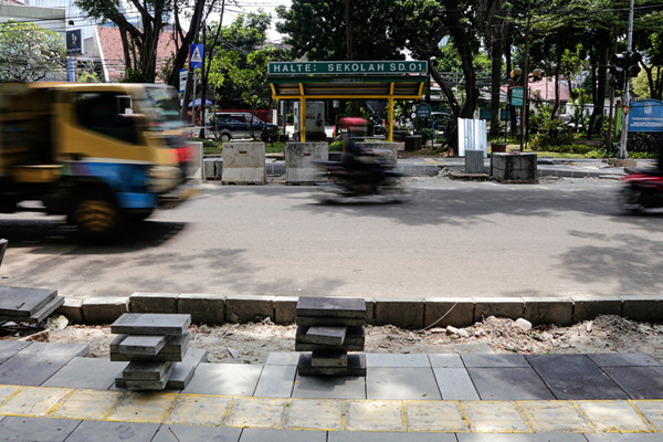 Pekerja menyelesaikan proyek revitalisasi trotoar di Jalan Senopati, Jakarta Selatan, Jumat (24/9/2021).