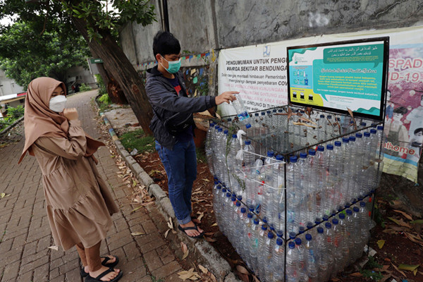 Warga merakit botol bekas menjadi tempat sampah di kawasan Situ Gintung, Tangerang Selatan, Banten, Sabtu (25/9/2021).
