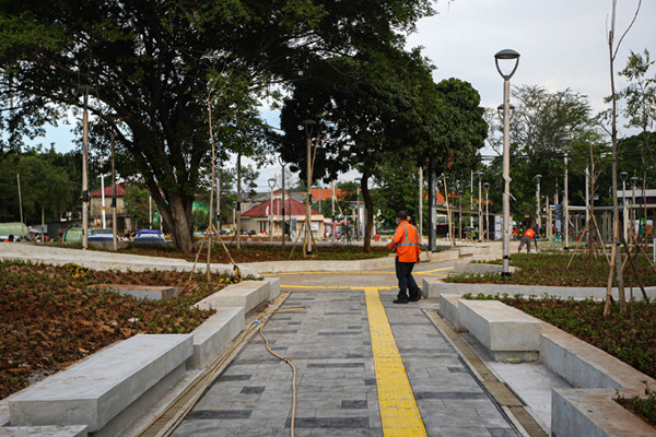 Para pekerja sedang menyelesaikan revitalisasi halaman Stasiun Manggarai, Jakarta Selatan, Minggu (26/9/2021).