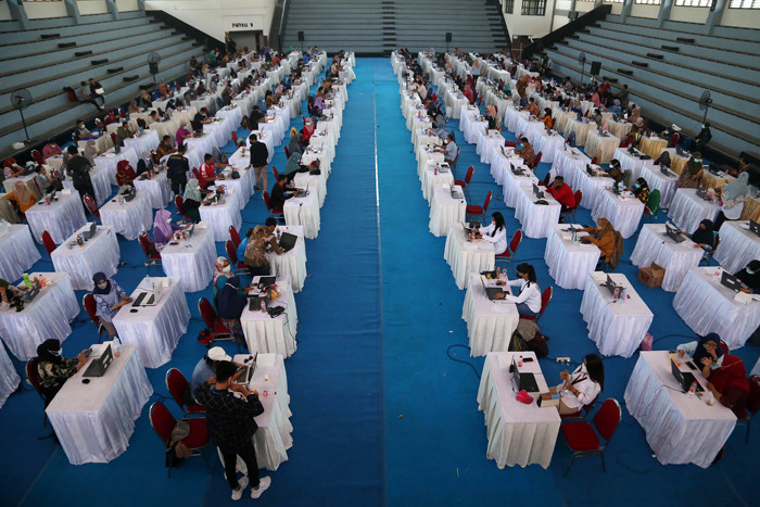 Petugas entry data peserta vaksin melakukan senam tangan untuk melenturkan ketegangan ketika menjalankan tugas di Surabaya, Jawa Timur, Kamis (30/9/2021).