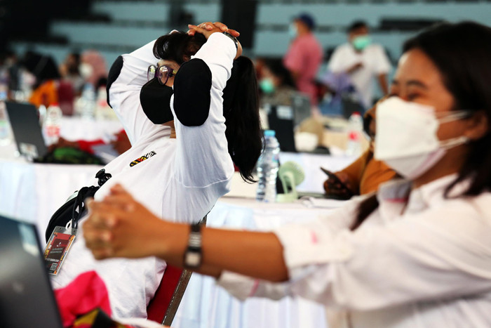 Petugas entry data peserta vaksin melakukan senam tangan untuk melenturkan ketegangan ketika menjalankan tugas di Surabaya, Jawa Timur, Kamis (30/9/2021).