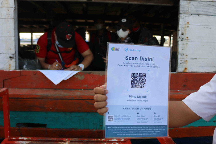 Calon penumpang menscan aplikasi PeduliLindung saat akan menaiki jasa transpotasi laut dan kapal cepat di Pelabuhan Kali Adem, Jakarta, Sabtu (2/10/2021).