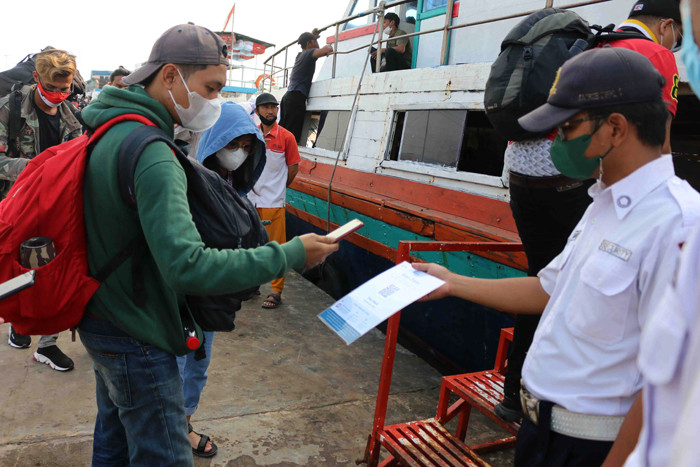 Calon penumpang menscan aplikasi PeduliLindung saat akan menaiki jasa transpotasi laut dan kapal cepat di Pelabuhan Kali Adem, Jakarta, Sabtu (2/10/2021).