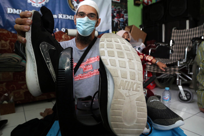 Para penyandang disabilitas mencuci sepatu dan helm gratis ketika mengikuti pelatihan cuci sepatu, tas dan helm di Surabaya, Jawa Timur, Selasa (5/10/2021).