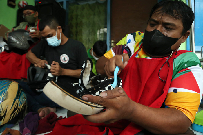 Para penyandang disabilitas mencuci sepatu dan helm gratis ketika mengikuti pelatihan cuci sepatu, tas dan helm di Surabaya, Jawa Timur, Selasa (5/10/2021).