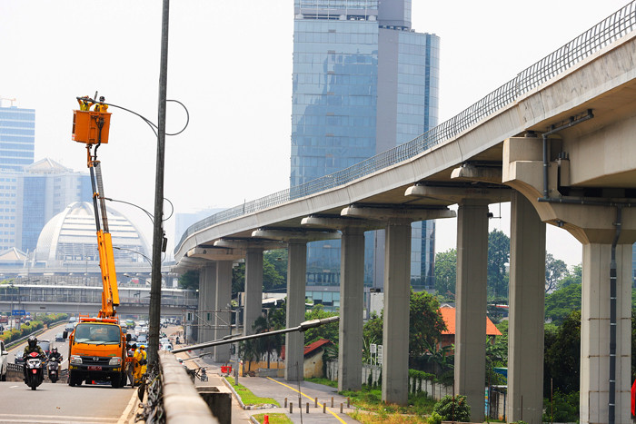 Petugas saat memperbaiki lampu penerangan di Jalan Gatot Subroto, Jakarta Selatan, Selasa (5/10/2021).