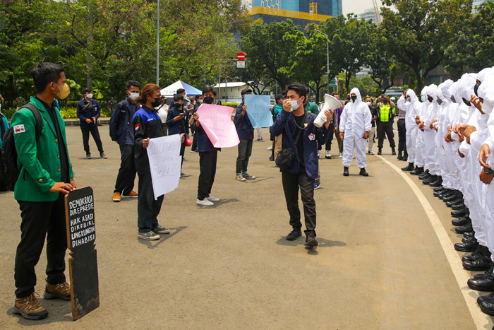 Mahasiswa membentangkan poster saat melakukan aksi unjuk rasa di kawasan Monas, Jakarta, Rabu, (6/10/2021).