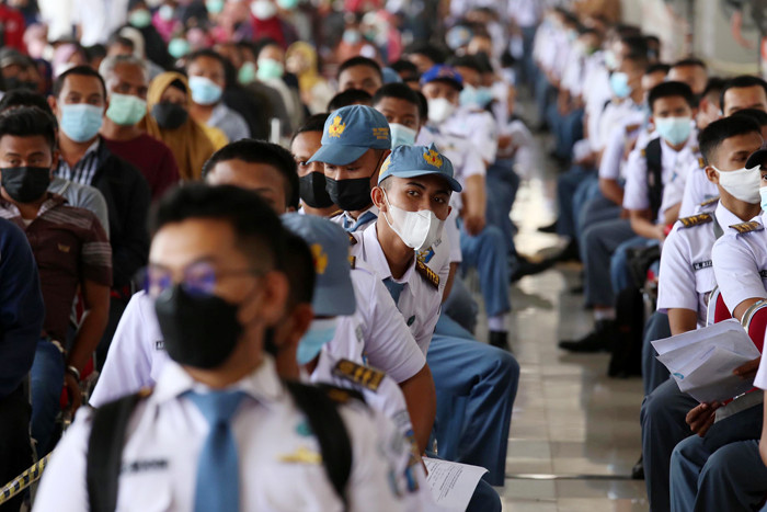 Ribuan warga mengantri untuk mendapatkan vaksin Covid-19 di Bandara Juanda Surabaya, di Sidoarjo Jawa Timur, Kamis (7/10/2021).