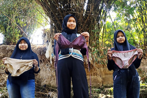 Sejumlah pemuda dari beberapa komunitas lingkungan memamerkan celana dalam hingga bra ketika membersihkan pohon plastik di Kali Bulusari, Minggu (10/10/2021).