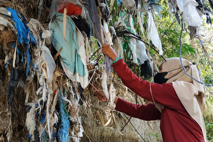 Sejumlah pemuda dari beberapa komunitas lingkungan memamerkan celana dalam hingga bra ketika membersihkan pohon plastik di Kali Bulusari, Minggu (10/10/2021).