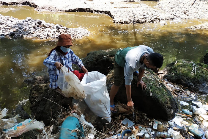 Sejumlah pemuda dari beberapa komunitas lingkungan memamerkan celana dalam hingga bra ketika membersihkan pohon plastik di Kali Bulusari, Minggu (10/10/2021).