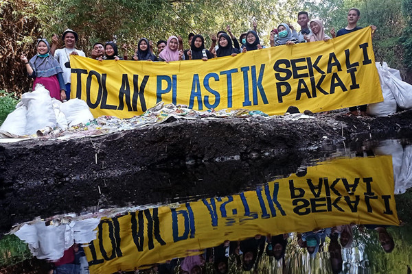 Sejumlah pemuda dari beberapa komunitas lingkungan memamerkan celana dalam hingga bra ketika membersihkan pohon plastik di Kali Bulusari, Minggu (10/10/2021).