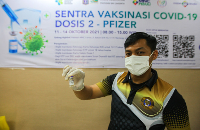 Petugas vaksinator memberikan suntikan vaksin Covid-19 jenis Pfizer untuk warga di Sentra Vaksinasi Gedung HighEnd MNC Center, Jakarta, Selasa (12/10/2021).