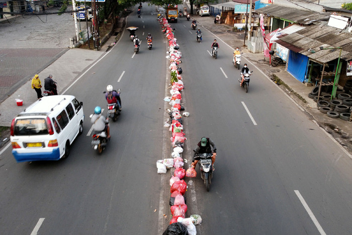 Foto drone pengendara motor berhenti dan membuang sampah ditengah Jalan Raden Fatah, Ciledug, Tangerang, Banten, Selasa (12/10/2021).