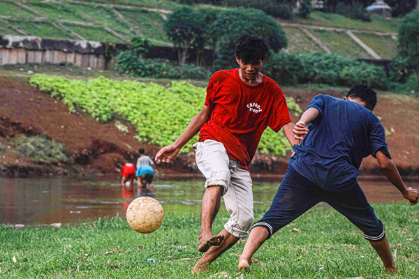 Sejumlah remaja memanfaatkan dataran sedimentasi lumpur kering untuk bermain sepak bola di kawasan Banjir Kanal Timur, Jakarta Timur, Rabu (13/10/2021).