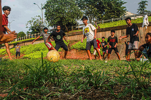 Sejumlah remaja memanfaatkan dataran sedimentasi lumpur kering untuk bermain sepak bola di kawasan Banjir Kanal Timur, Jakarta Timur, Rabu (13/10/2021).