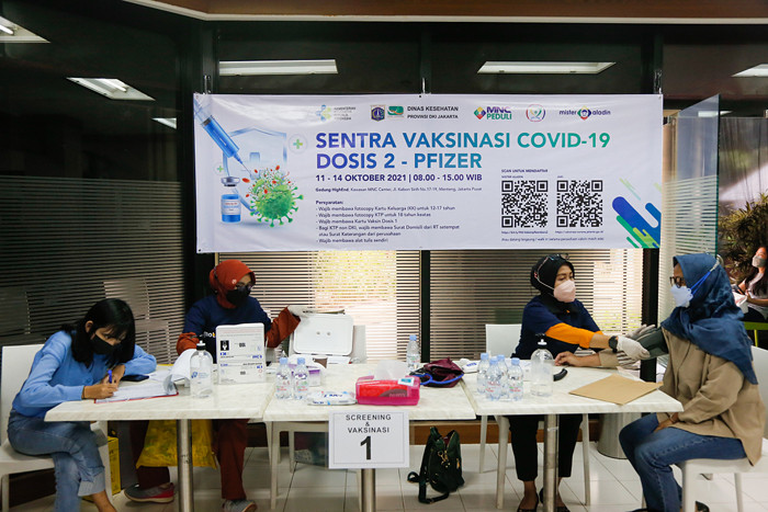 Vaksinator menyuntikkan vaksin Covid-19 jenis Pfizer kepada warga di Sentra Vaksinasi Dosis kedua MNC Peduli di Gedung HighEnd, MNC Center, Kamis (14/10/2021).