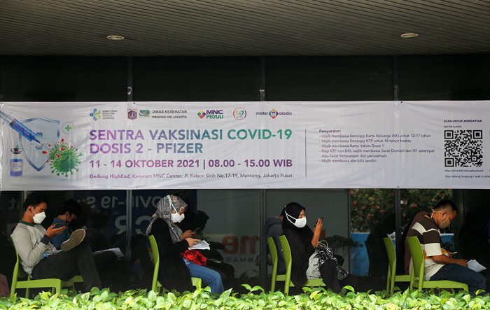 Vaksinator menyuntikkan vaksin Covid-19 jenis Pfizer kepada warga di Sentra Vaksinasi Dosis kedua MNC Peduli di Gedung HighEnd, MNC Center, Kamis (14/10/2021).