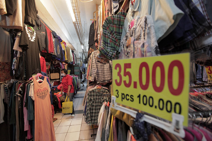 Pedagang sedang melayani calon pembeli pakaian bekas yang di jual di Pasar Senen, Jakarta, Kamis (14/10/2021).