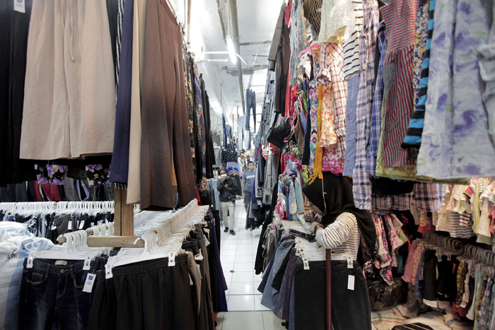 Pedagang sedang melayani calon pembeli pakaian bekas yang di jual di Pasar Senen, Jakarta, Kamis (14/10/2021).