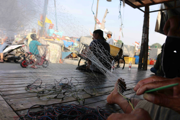 Nelayan melakukan aktivitas di kampung nelayan Cilincing, Jakarta Utara, Kamis (14/10/2021).
