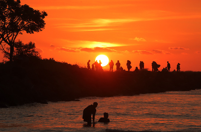 Sejumlah warga menikmati suasana senja di Pantai Bosowa Makasar, Jumat (15/10/2021).