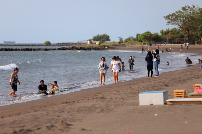 Sejumlah warga menikmati suasana senja di Pantai Bosowa Makasar, Jumat (15/10/2021).