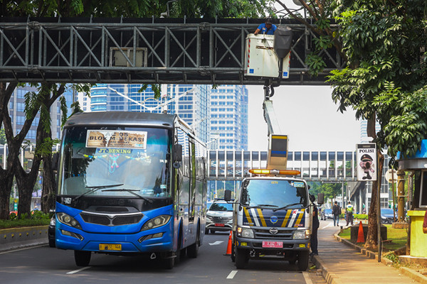 Petugas Dinas Perhubungan (Dishub) Provinsi DKI Jakarta melakukan perawatan videotron di jalan Jenderal Sudirman, Jakarta Pusat, Minggu (17/10/2021).