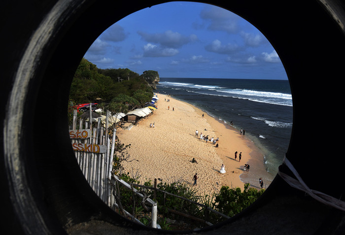 Pengunjung menikmati keindahan alam dan derunya ombak di Pantai Indrayanti, Kabupaten Gunungkidul, Daerah Istimewa Yogyakarta (DIY), Sabtu (16/10/2021).