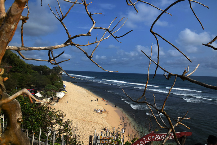 Pengunjung menikmati keindahan alam dan derunya ombak di Pantai Indrayanti, Kabupaten Gunungkidul, Daerah Istimewa Yogyakarta (DIY), Sabtu (16/10/2021).