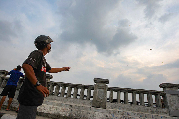 Sejumlah warga bermain layang-layang di Flyover Kalibata, Jakarta, Minggu (17/10/2021).